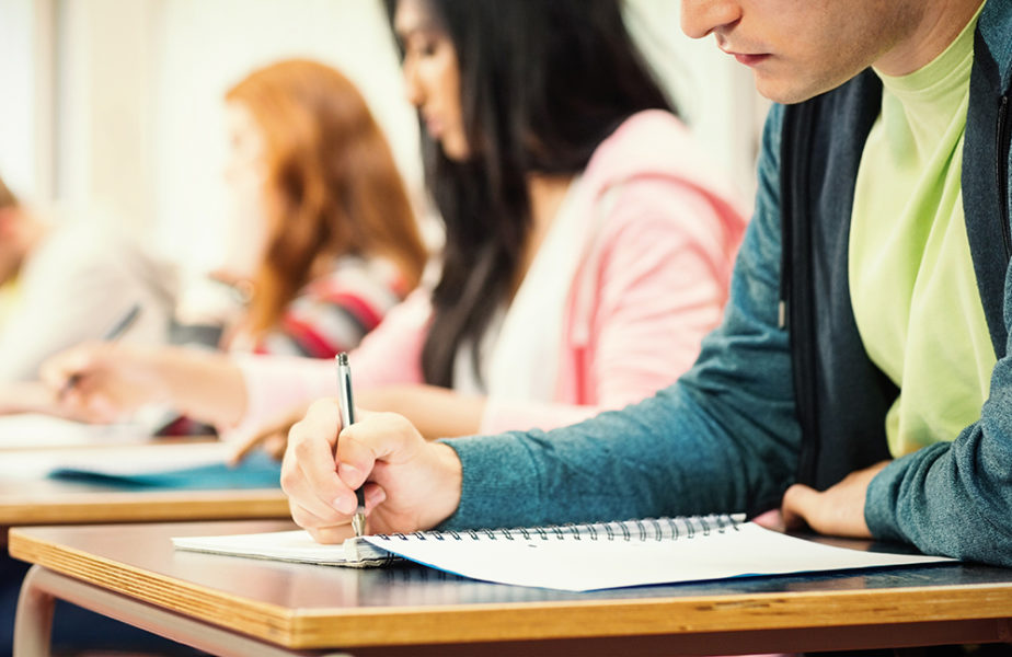Young students writing notes in classroom Young students writing notes in classroom