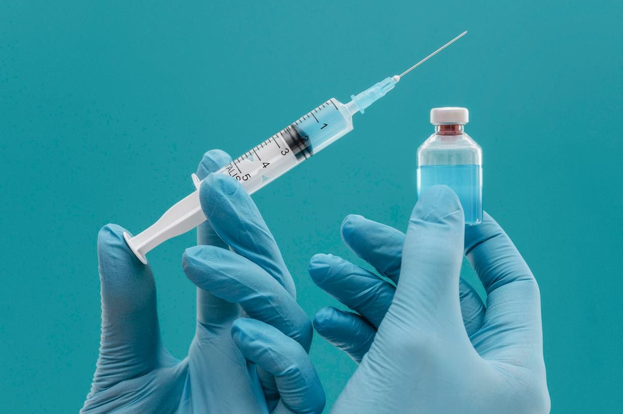 vaccine-bottle-and-syringe-held-by-doctor-with-gloves-jpg vaccine-bottle-and-syringe-held-by-doctor-with-gloves-jpg