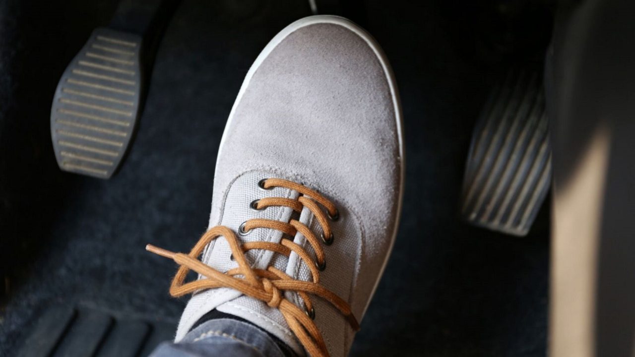 96d3cc00-pedal-do-freio-sendo-acionado-por-pe-calcado-com-tenis-bege-claro